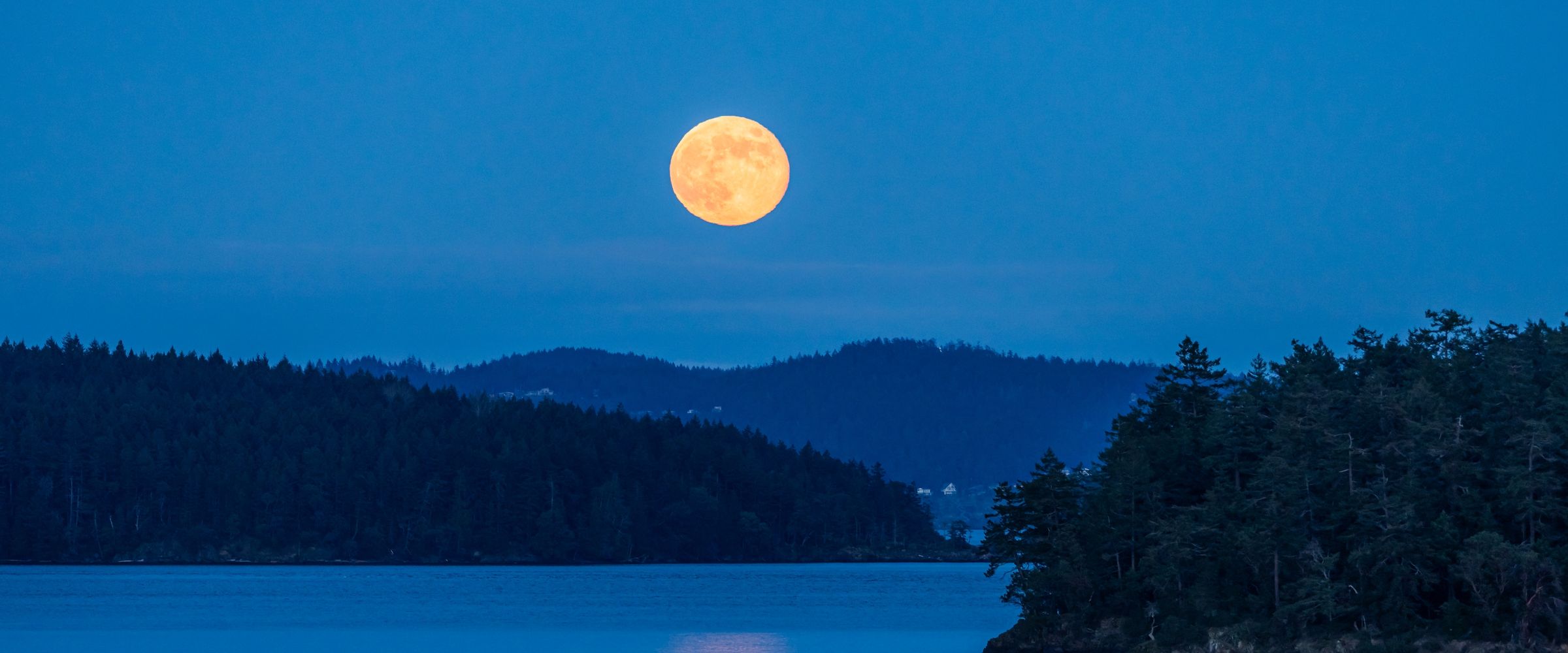 A full Moon reflected in still water at night